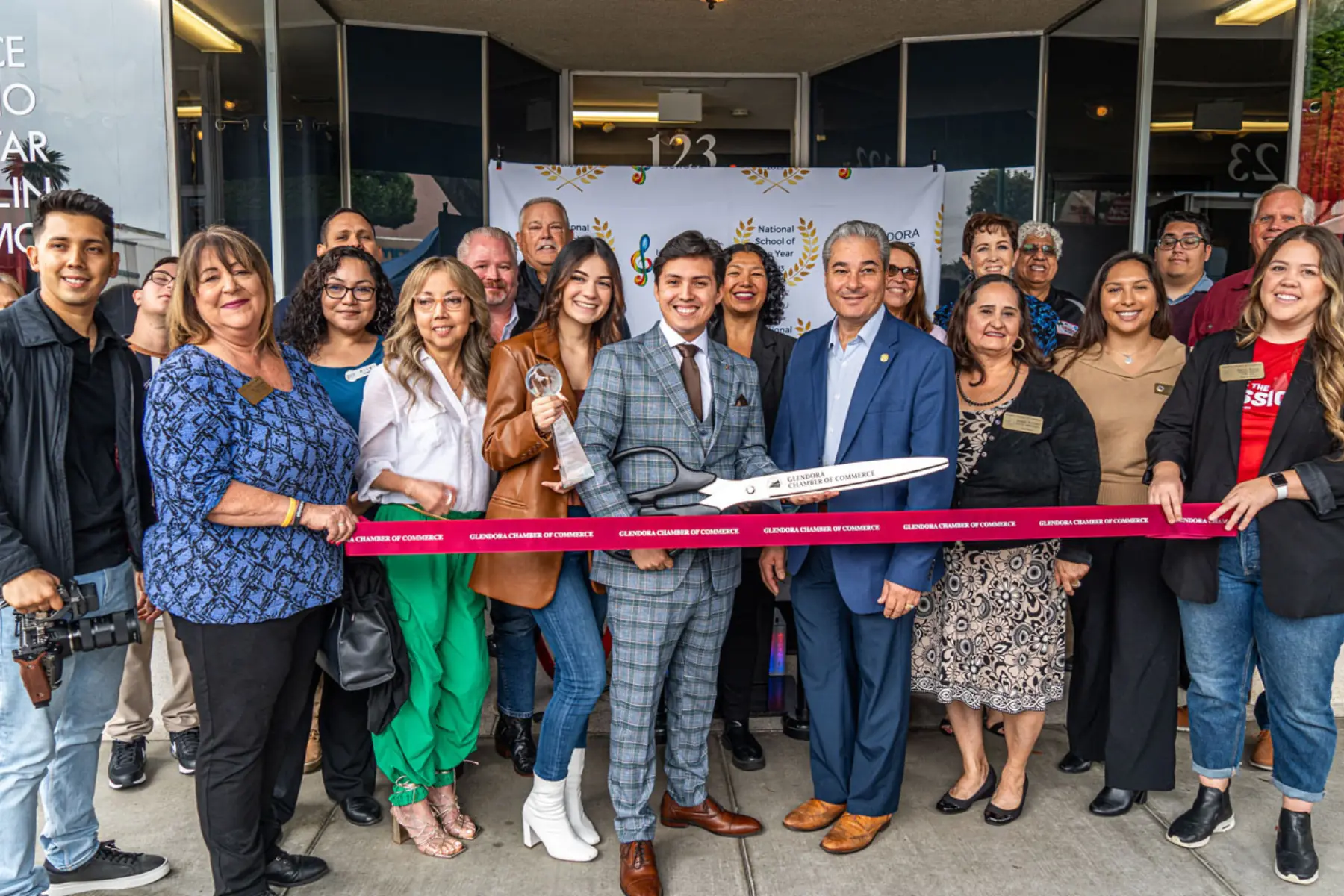 Luis and local families at the ribbon cutting for a new music school location